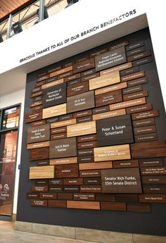 a large wall with many names on it in front of a building that has stairs and balconies