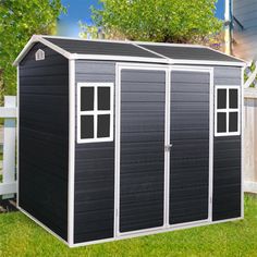 a black and white storage shed in the yard