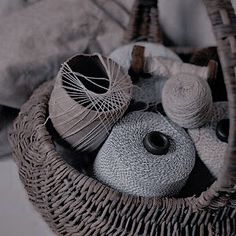 a basket filled with yarn and balls of thread