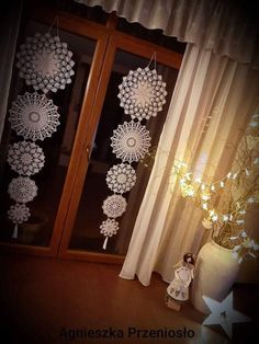 the window is decorated with white doily and lights