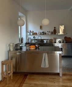 a kitchen with stainless steel appliances and wooden floors