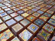 many colorful tiles are arranged in rows on the floor