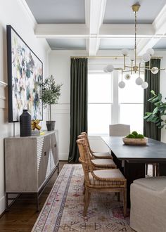 a dining room table with chairs and a rug on the floor in front of it