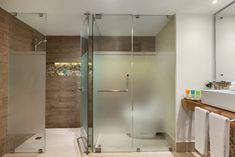 a bathroom with a glass shower door and sink