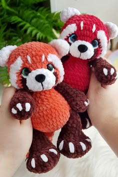 two stuffed animals are held in the palm of someone's hand, one red and one brown