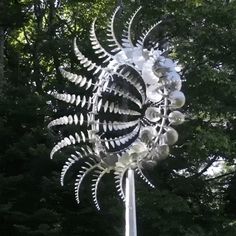 a large metal sculpture in the middle of a forest