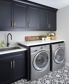 a washer and dryer in a room with black cabinets