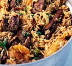 a bowl filled with rice and meat next to an orange slice on the side,