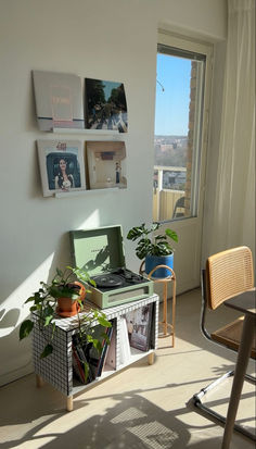 a living room filled with furniture next to a window and potted plant on top of a table