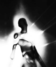 a black and white photo of a person's foot in the air with light coming through