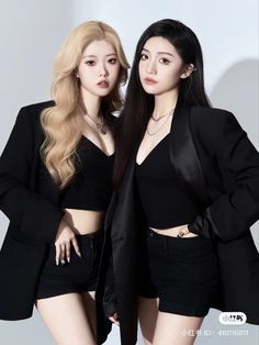 two young women standing next to each other wearing black outfits and posing for the camera