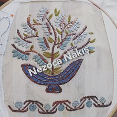 a close up of a embroidery on a piece of cloth with the words neeze naks