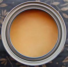 an open can of brown paint sitting on top of a rug