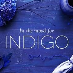 the words in the mood for indigo are displayed on a wooden surface with blue flowers