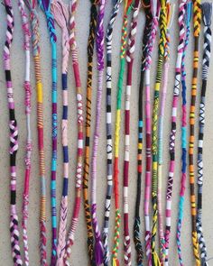 many different colored braids are lined up on the wall