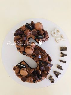 a white plate topped with a cake covered in lots of chocolates and candies