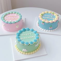 three decorated birthday cakes sitting on top of a white table next to eachother