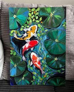 a painting of two koi fish and lily pads on a couch with white pillows