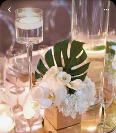 a table with candles, flowers and wine glasses on it for an elegant centerpiece