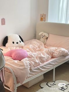 there is a bed with pink sheets and pillows on top of it in the room