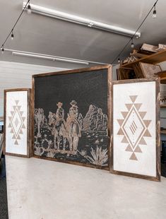 three framed artwork pieces on the wall in an office space with desks and chairs