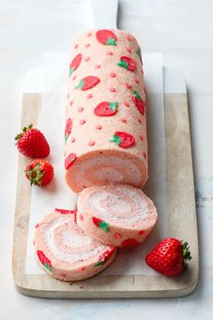 sliced strawberry roll on cutting board with strawberries