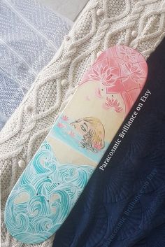 two snowboards sitting on top of a bed next to each other, one is blue and the other is pink