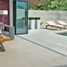 a living room with a couch and table next to a swimming pool