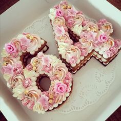 two heart shaped cookies decorated with pink and white flowers