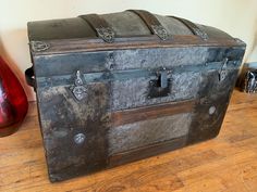 an old trunk sitting on top of a wooden floor