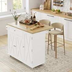 a kitchen island with two stools in front of it and bottles on the counter