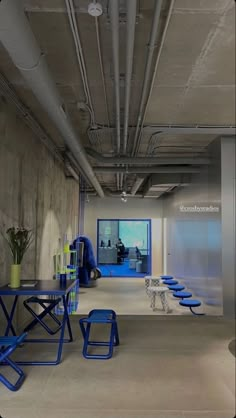 an empty room with blue chairs and tables