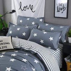 a bedroom with grey walls and white stars on the comforter, black and white bedding