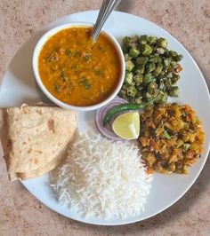 a white plate topped with rice, beans and other foods