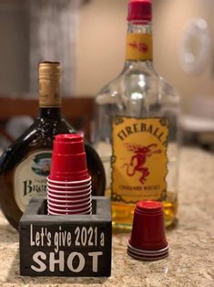 bottles and cups are sitting on the counter next to each other in front of an empty bottle