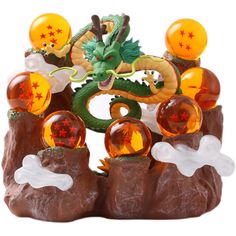 a dragon figurine sitting on top of a pile of rocks with balls in it