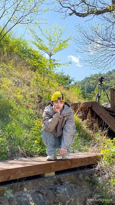 a young boy is sitting on a wooden bridge