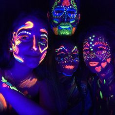 three girls with their faces painted in fluorescent colors