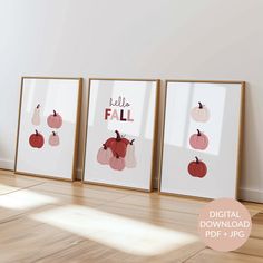 three framed art prints with pumpkins and apples on them in front of a white wall