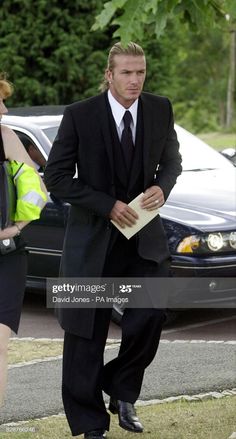 a man in a suit and tie walking down the street