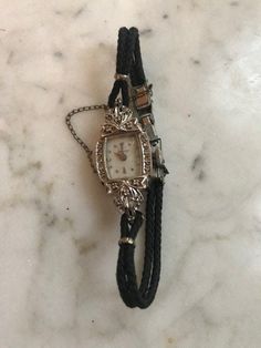 "A lovely antique ladies Hamilton wrist watch which is a fresh estate find. Very nice original condition & seems to be in working order when wound. Impressed on reverse 14k white gold with diamond accents on each side of the watch face. Very dainty, petite & elegant. Measures: 6.5\" length" Handmade Luxury Vintage Watch Accessories, Antique Diamond Watch In White Gold, Antique Diamond Watch For Evening, Antique Hallmarked Diamond Watch, Antique Diamond Watch With Diamond Hour Markers, Collectible White Gold Elegant Watches, Vintage Diamond Watch With Diamond Hour Markers For Evening, Vintage White Gold Diamond Jewelry And Watches, Vintage White Gold Diamond Jewelry