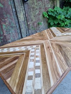 a wooden table that has been made out of wood and tiles on top of it