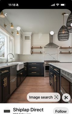 a kitchen with black cabinets and white walls