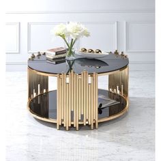 a black and gold coffee table with flowers in it on a marble floor next to a white wall