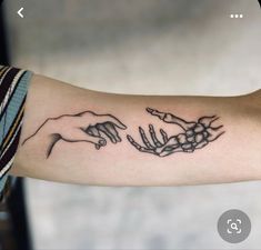 a tattoo on the arm of a woman with hands reaching out for something to touch