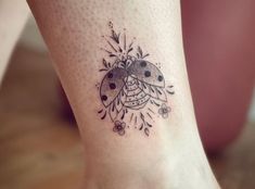 a ladybug tattoo on the foot of a woman's leg is shown