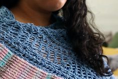 a close up of a woman wearing a knitted shawl