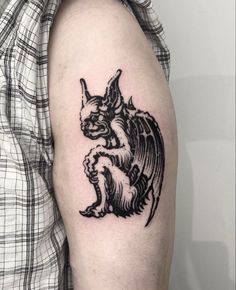 a black and white cat tattoo on the arm