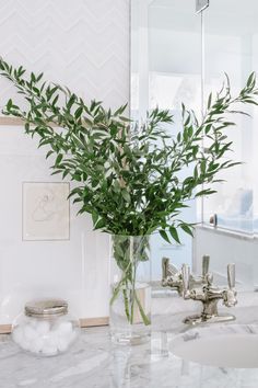 a vase filled with flowers sitting on top of a bathroom counter