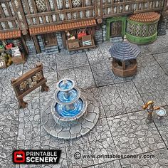 an aerial view of a fountain in the middle of a courtyard with benches and tables